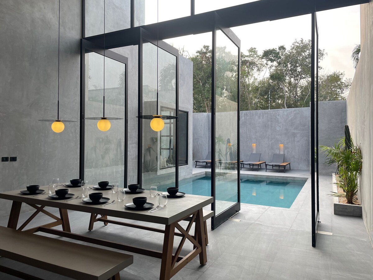 Casa Arroqueno área de alberca de lujo rodeada de exuberante vegetación de selva y arquitectura moderna